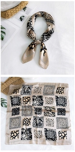Detail of silk square scarf featuring leopard and zebra animal prints in champagne gold
