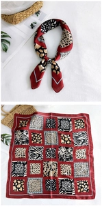 Detail of red square silk scarf with vintage animal prints and elegant leopard pattern