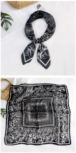 Detail of black and white paisley silk-like square scarf with floral pattern and border