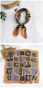 Detailed view of square silk scarf with orange tones and animal print geometric pattern