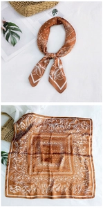 Detail of caramel silk square scarf with white paisley floral print and smooth finish