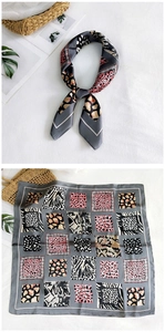 Detail of elegant satin square scarf with mixed leopard, zebra, and snake animal prints
