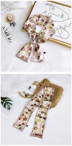 Detailed close-up of a floral silk scarf twilly with elegant leaf patterns and diagonal cut ends