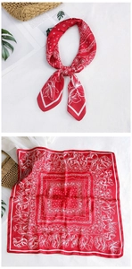 Close-up of red paisley square silk scarf showing floral print and smooth texture