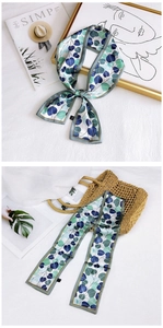 Detail of leaf pattern silk twilly tied on a straw bag handle for stylish decoration