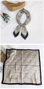 Detailed view of paisley square scarf with silk texture and elegant gold tones