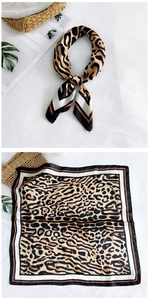 Detailed view of leopard print silk scarf with rolled edges on a styled background