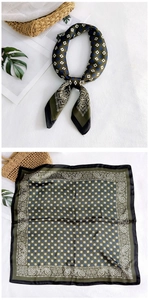 Detail of silk square scarf in olive green with geometric patterns and paisley border