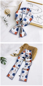 Detail of floral twilly scarf with abstract tree print and a branded origin label