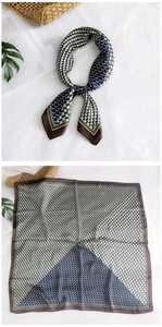 Detail of silk square scarf featuring green and blue geometric patterns and scales