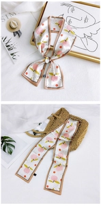 Detail of floral twilly silk scarf with peach print tied on a summer straw bag