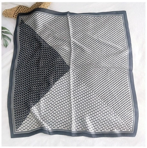 Detail of silk-like square scarf featuring black and white geometric patterns and textures