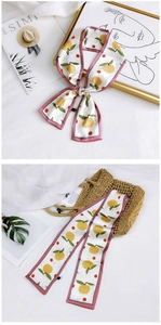 Close-up of fruit print silk scarf with lemon pattern and pink contrast borders