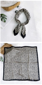 Detail of silk square scarf featuring leopard print and elegant satin sheen texture