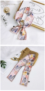 Close-up of abstract floral silk scarf with vibrant patterns and elegant hem detail