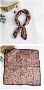Detailed view of leopard print silk scarf with warm brown tones and stylish border