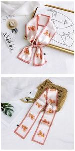 Detail of light pink floral long narrow silk scarf with pumpkin festive prints on a woven bag
