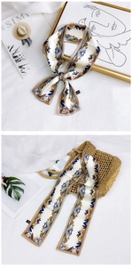 Detailed close-up of floral twilly scarf tied in a bow and wrapped on a woven bag handle