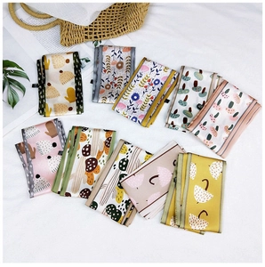 Detail view of nine floral printed narrow silk scarves in assorted colors and patterns