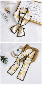 Detail of floral polyester skinny scarf with green polka dot edge and soft cream base