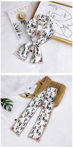 Detail of floral silk twilly scarf with cartoon mushroom print on polished cream fabric