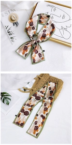 Detail of silk scarf with mushroom patterns and green hand-stitched borders on a bag