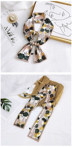 Detail of floral twilly scarf with 100% polyester wash label on white woven background