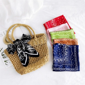 Multiple paisley pattern square silk scarves with boho straw bag decorative styling