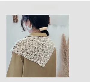 Close-up of vintage floral hollow lace triangle scarf with delicate wavy crochet edge