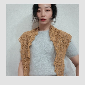 Detail of yellow crochet lace triangular scarf styled with a light blue mohair knit top