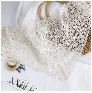 Detail of white lace floral embroidery with delicate scalloped edges and soft texture