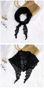 Detail of black lace neckerchief with floral hollow patterns and scalloped edges