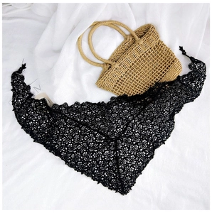Detail of black crochet triangle shawl with delicate hollow geometric lace patterns
