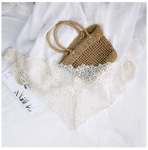 Detailed close-up of white floral lace triangle scarf with intricate镂空patterns and soft texture