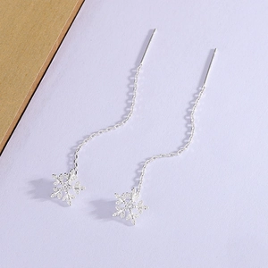 Close-up of silver snowflake threader earrings with delicate tassels and sparkling crystals