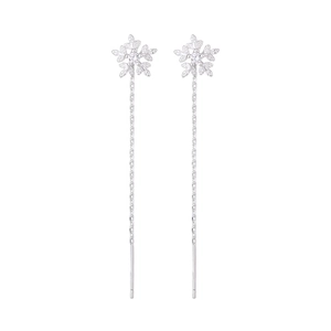 Close-up of silver snowflake tassel earrings with delicate chains and zircons