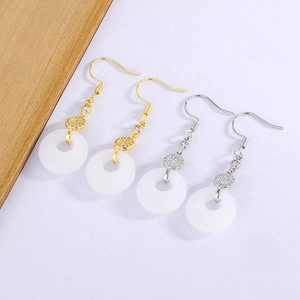 Detail of white jade chalcedony drop earrings with gold and silver Fu character accents