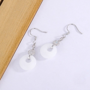 Detail of silver drop earrings featuring white chalcedony donuts and Fu character charms