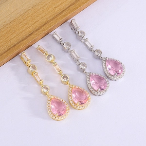 Macro detail of luxury pear-cut pink diamond drop earrings with gold and silver plating