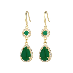 Detail of vintage gold drop earrings with teardrop green stones and pavé set crystals