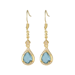Macro shot of gold teardrop earrings with blue crystals and sparkling micro-pave diamonds