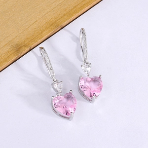 Elegant silver heart earrings with pink gemstones and ear hooks on a white background