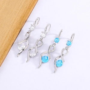 Close-up of elegant intertwining silver drop earrings with blue and white crystals