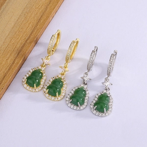 Macro detail of green chalcedony hulu earrings with zircon inlays in gold and silver