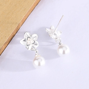 Close-up of flower pearl earrings with silver petals and large round white pearls