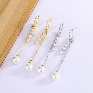 Macro view of long tassel earrings with sparkling zircons and white round pearls