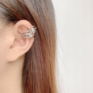 Macro detail of silver rose ear cuff with layered vintage thorn-like metal design