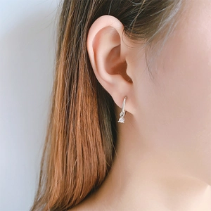 Close-up of silver geometric hoop earring with a round sparkling cubic zirconia pendant