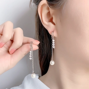 Close-up of long tassel earrings with sparkling cubic zirconia and white pearls