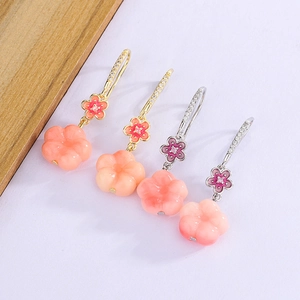 Macro view of peach blossom drop earrings with pink carved petals and zircon ear hooks